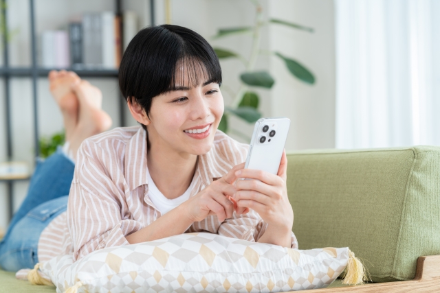 ごろ寝でスマホの女性