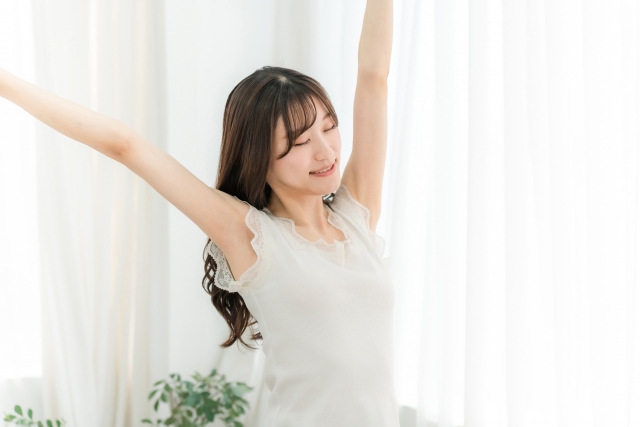 寝起き・起床時に朝日を浴びる女性（快眠）