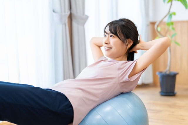 バランスボールを使って運動する女性