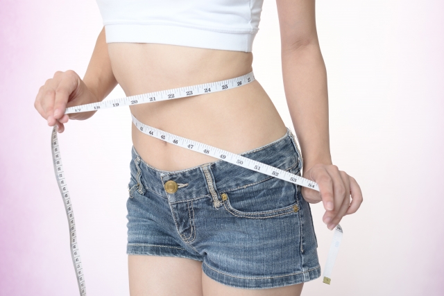 ウエストを測る女性